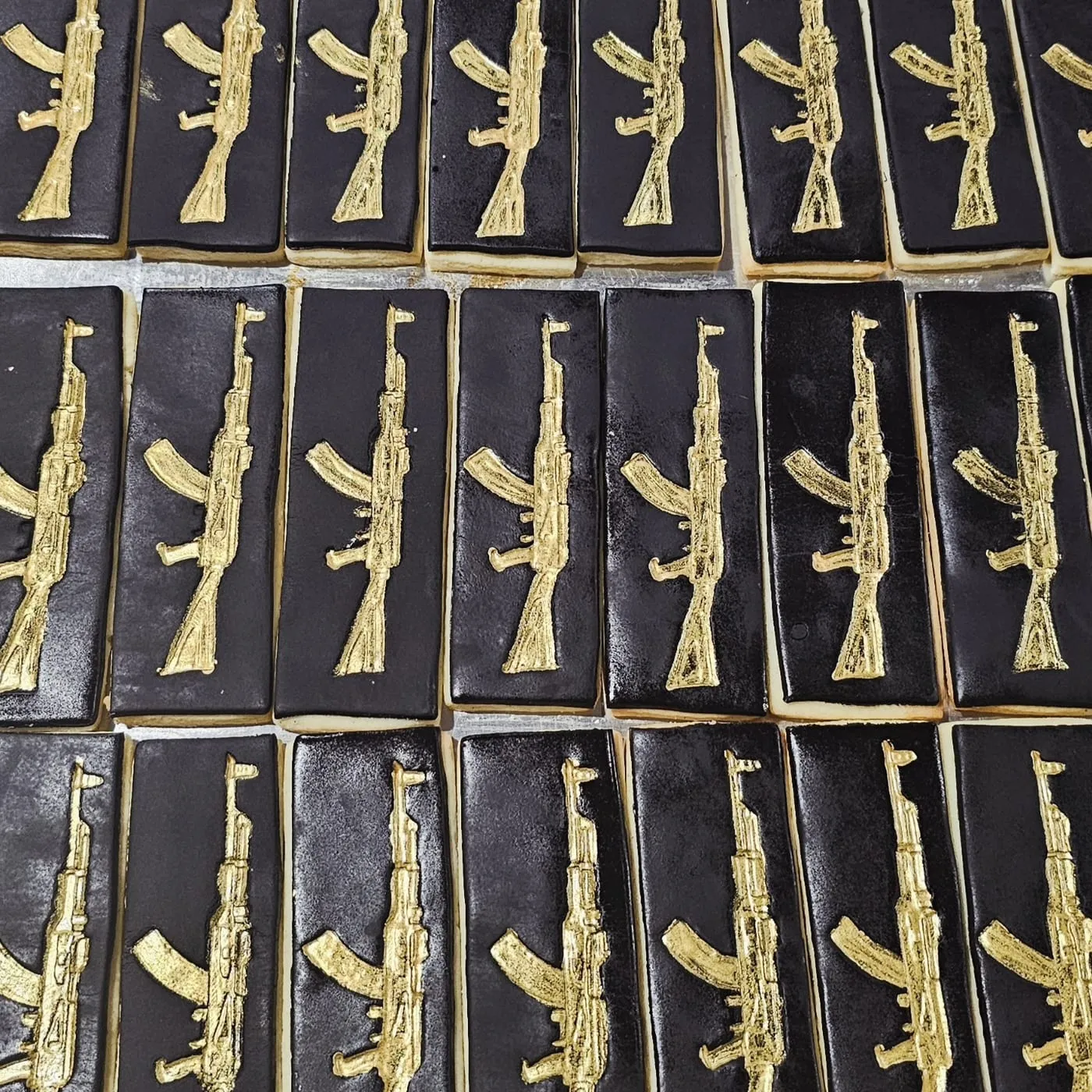Gold rifles on black fondant